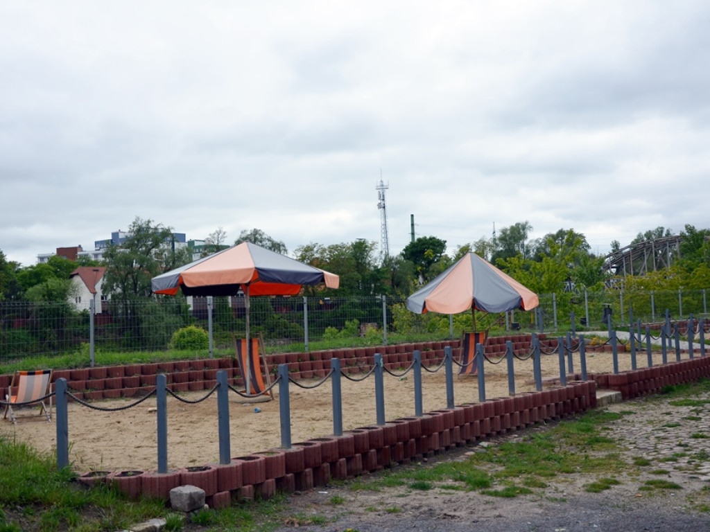 Miejska plaża: cztery leżaki i wyblakłe parasole. To raczej szpeci marinę niż dodaje jej uroku