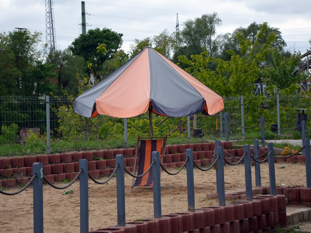 Miejska plaża: cztery leżaki i wyblakłe parasole. To raczej szpeci marinę niż dodaje jej uroku