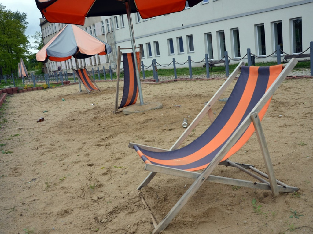 Miejska plaża: cztery leżaki i wyblakłe parasole. To raczej szpeci marinę niż dodaje jej uroku