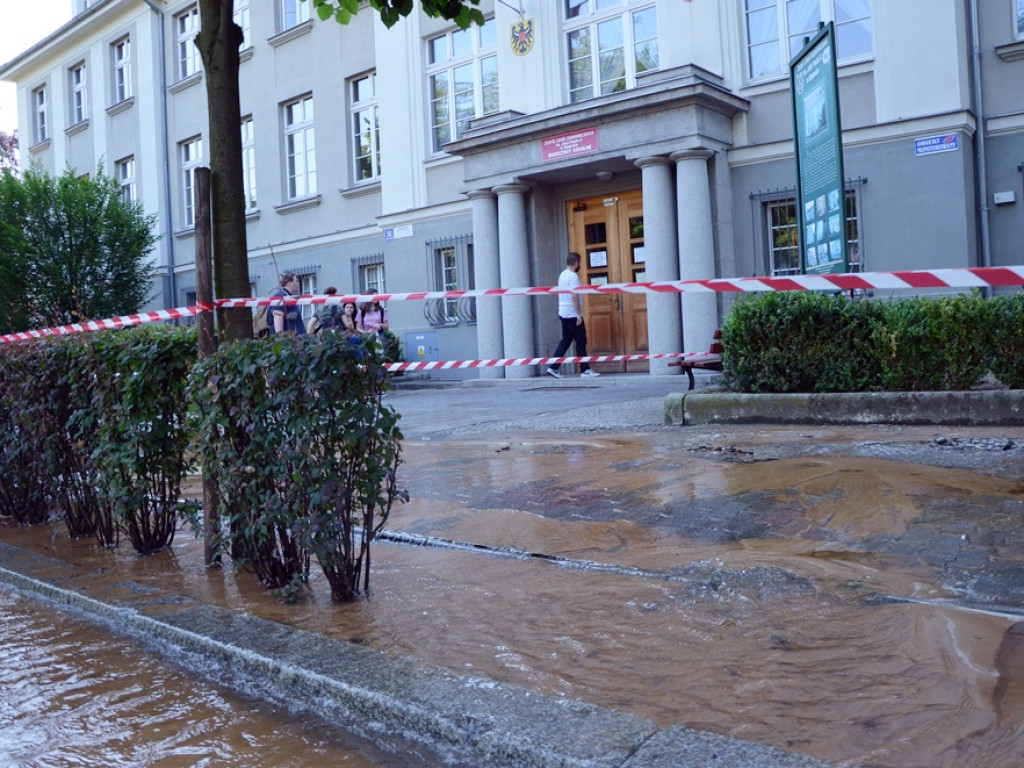 Awaria rury wodociągowej na Jedności Robotniczej. Strumień wody cieknie ulicą
