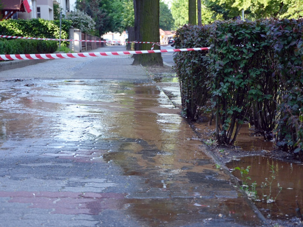Awaria rury wodociągowej na Jedności Robotniczej. Strumień wody cieknie ulicą