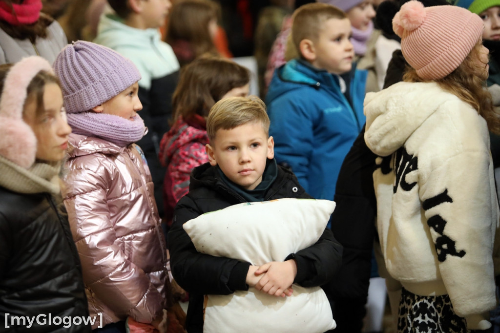 Dzieci pod stajenką z kocami i poduszkami