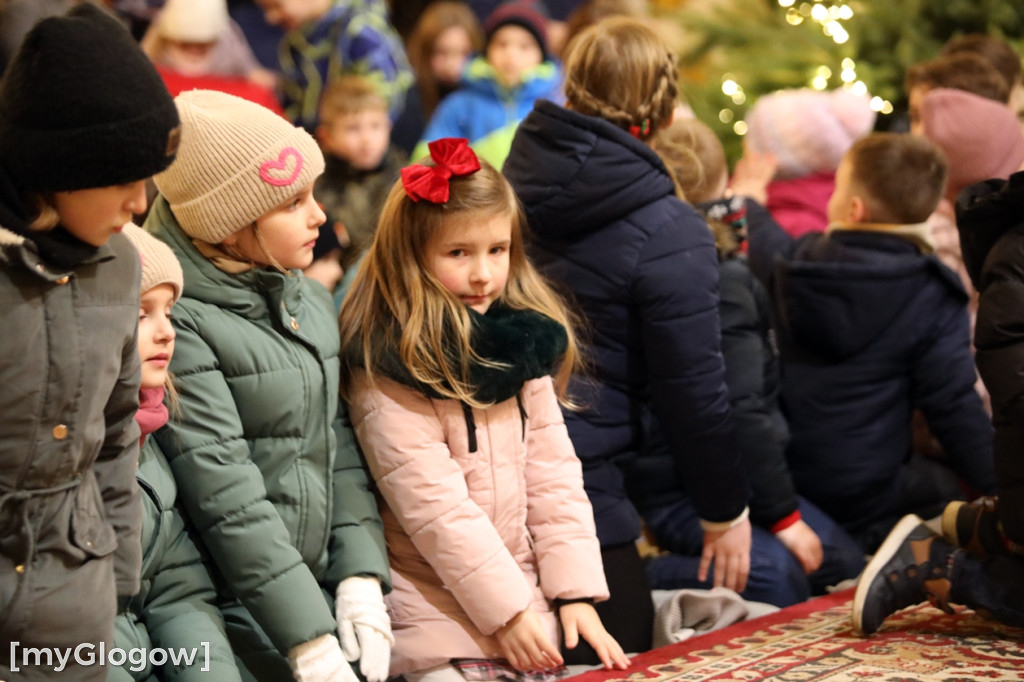 Dzieci pod stajenką z kocami i poduszkami