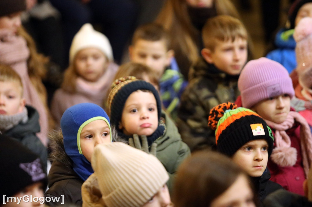 Dzieci pod stajenką z kocami i poduszkami