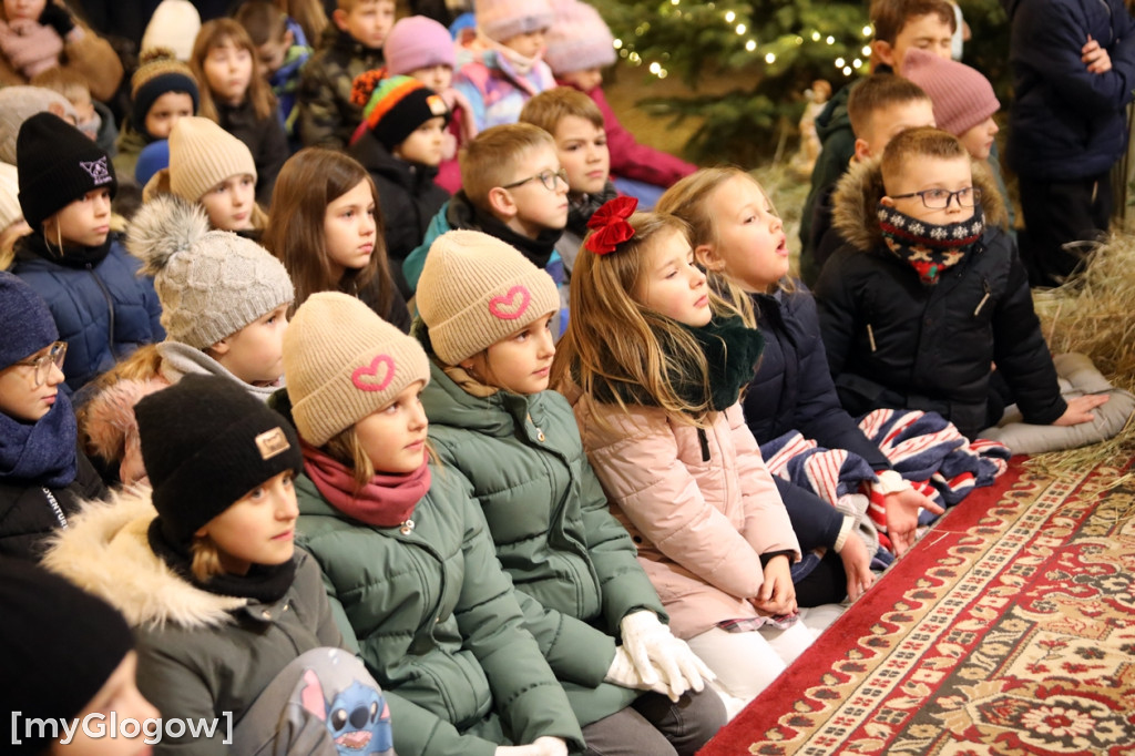 Dzieci pod stajenką z kocami i poduszkami