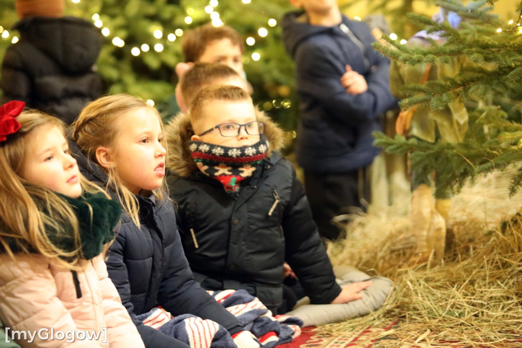 Dzieci pod stajenką z kocami i poduszkami