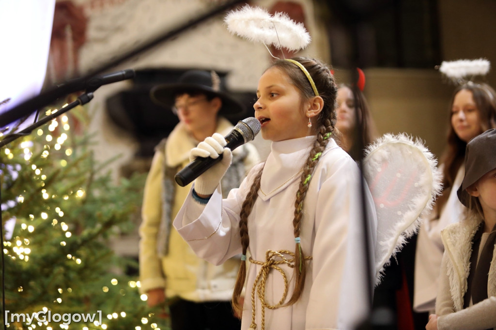 Dzieci pod stajenką z kocami i poduszkami