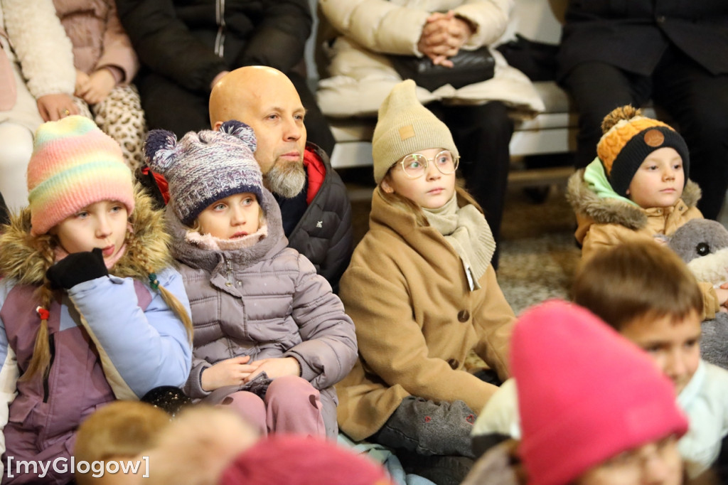 Dzieci pod stajenką z kocami i poduszkami