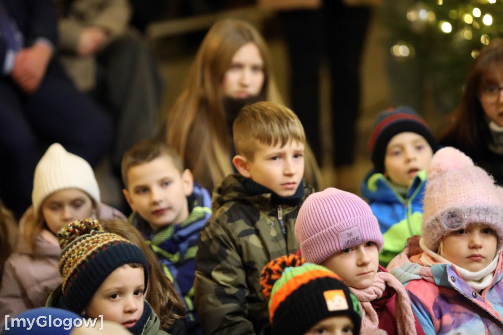 Dzieci pod stajenką z kocami i poduszkami
