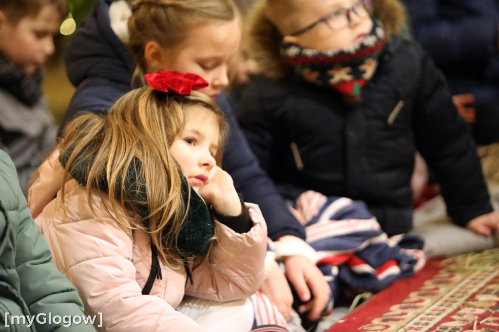 Dzieci pod stajenką z kocami i poduszkami